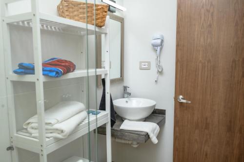 a bathroom with a sink and a shelf with towels at Depto. 2 rec. con acceso al Río in Boca del Río