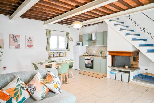 a kitchen and living room with a couch and a staircase at InnPisaRentals - Cozy Flat by the Airport in Pisa