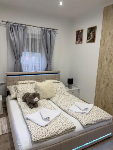 a bedroom with a bed with a teddy bear on it at Barackvirág-Vendégház in Érpatak