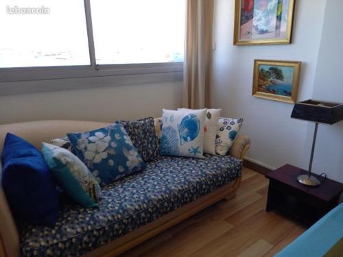 a couch with pillows on it in a living room at La Goelette 4 in Toulon