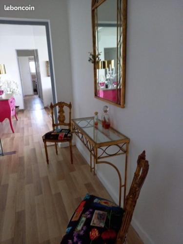a living room with a table and chairs and a mirror at La Goelette 4 in Toulon