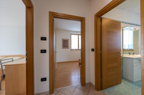 a bathroom with a wooden door and a sink at Agritur Giovanazzi in Arco