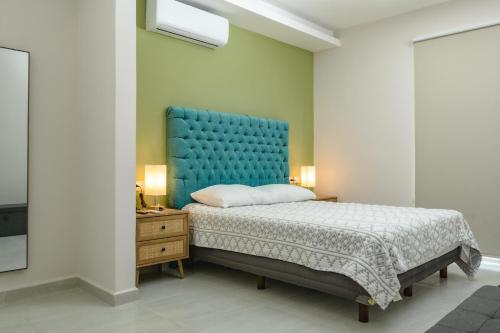 a bedroom with a large bed with a blue headboard at Depto. 2 rec. en Playa Mocambo in Boca del Río