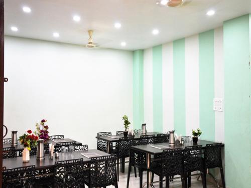 uma sala de jantar com mesas e cadeiras e uma parede listrada em HOTEL ATA INN AND RESTAURANT (20 Mtrs from Dargah), Ajmer em Ajmer