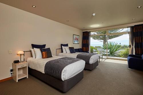 a hotel room with two beds and a balcony at The White Morph - Heritage Collection in Kaikoura