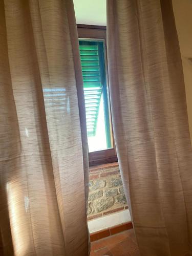 a window with brown curtains in a room at La casa del colle in Colle di Buggiano