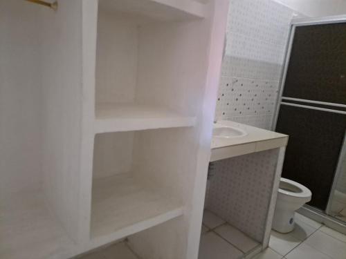 a white bathroom with a toilet and a sink at Casa vacacional SAMUEL in Honda