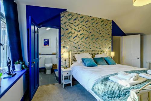 a bedroom with a large bed with blue walls at 3 Bed in Kelling oc-w27424 in Kelling