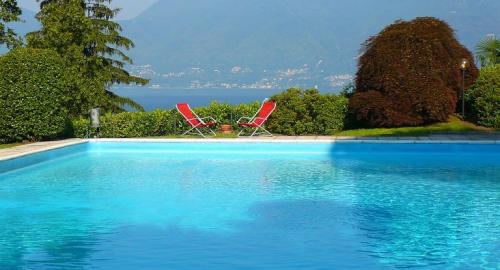 a swimming pool with two chairs and the water at Casa Sophie in Luino