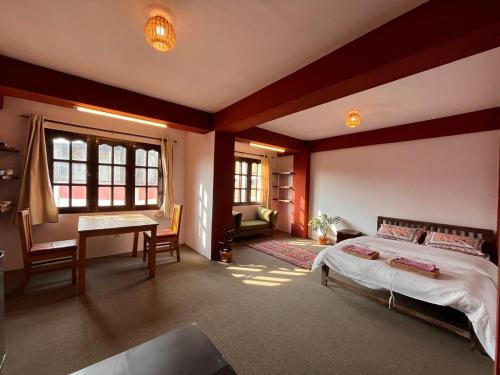 a bedroom with a bed and a desk in it at Avalokiteśvara Āvāsa in Kathmandu
