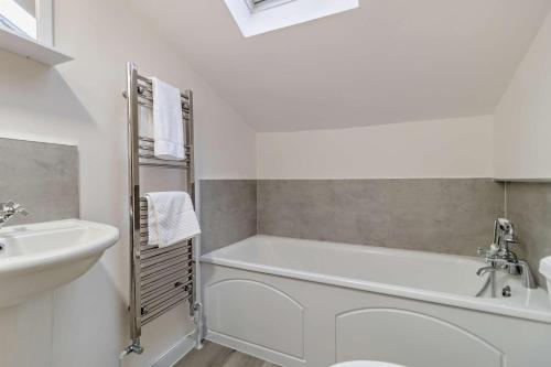 a white bathroom with a tub and a sink at 2 Bed in Lavenham oc-s30055 in Lavenham