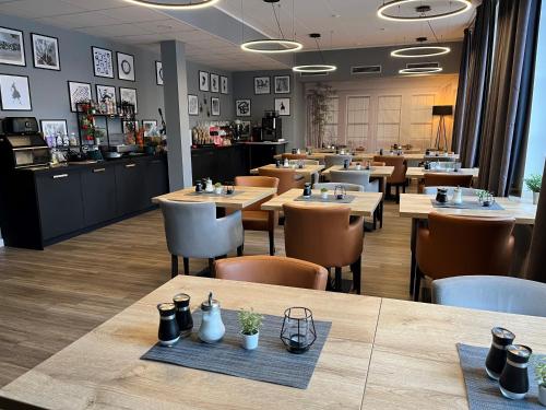 a dining room with tables and chairs in a restaurant at DORMERO Hotel Xanten in Xanten
