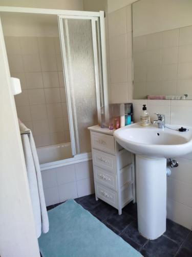 a bathroom with a sink and a mirror and a tub at 4-As Andar-Moradia Castelo in Guimarães