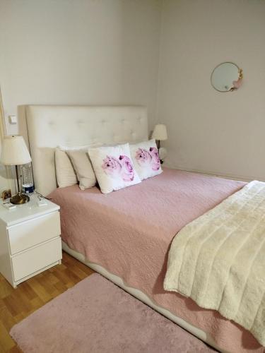 a bedroom with a bed with pink and white pillows at 4-As Andar-Moradia Castelo in Guimarães