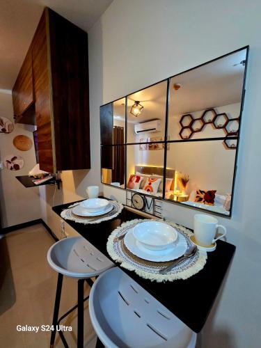a kitchen with two stools and a counter with plates on it at staycaSHAWN studio in Lapu Lapu City
