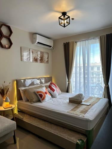 a bedroom with a large bed with a window at staycaSHAWN studio in Lapu Lapu City