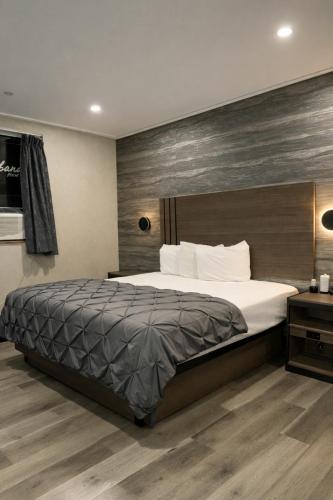 a bedroom with a large bed and a wooden wall at Cabana Hotel Yankee Stadium in Bronx