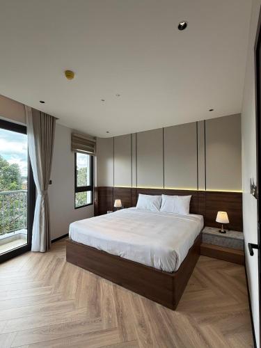 a bedroom with a large bed and a large window at Ama Retreat in Buôn Enao