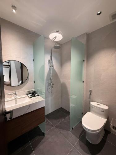 a bathroom with a toilet and a sink and a mirror at Ama Retreat in Buôn Enao