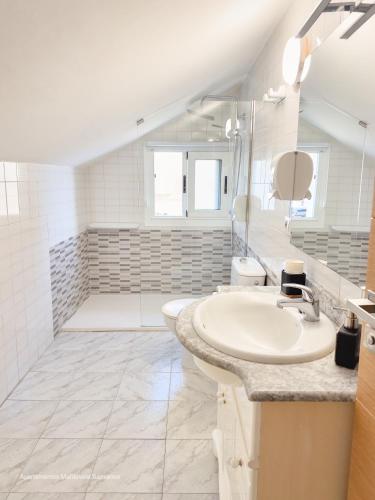 a white bathroom with a sink and a shower at Apartamento Mardevela in Sanxenxo