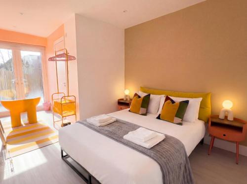 a bedroom with a large white bed with yellow accents at Zozy Clitterhouse in London