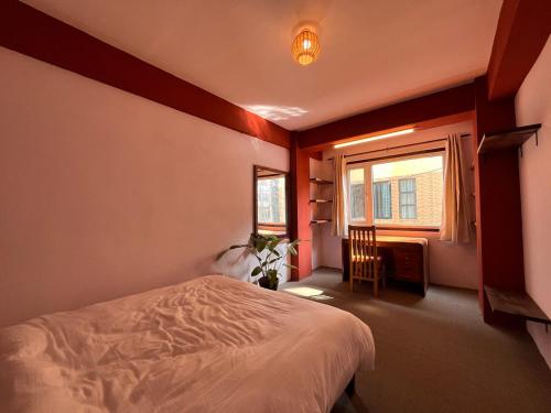 a bedroom with a bed and a window at Mandāravā Āvāsa in Kathmandu