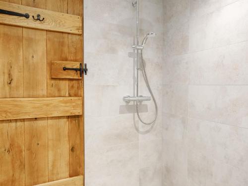 a shower with a wooden door in a bathroom at 4 Bed in Dunstable oc-93632 in Totternhoe