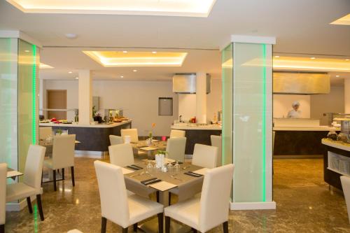 a dining room with a table and white chairs at Hotel Luxor in Playa de Palma
