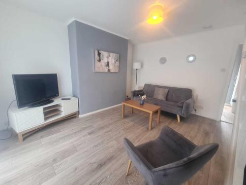 a living room with a couch and a television at Homely 2 Bedroom Dudley in Seaton Burn