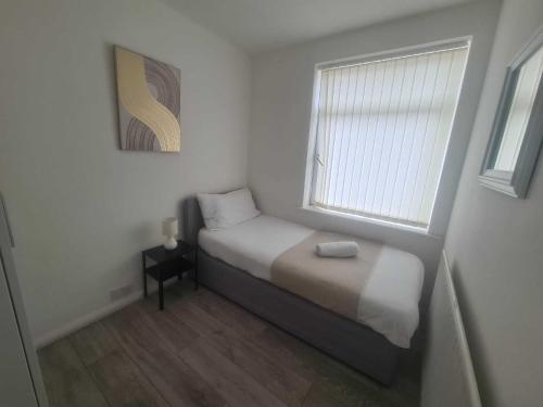 a small bedroom with a bed and a window at Homely 2 Bedroom Dudley in Seaton Burn