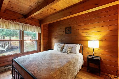 a bedroom with a bed in a log cabin at 4-Season Family Base! 13 Mi to Lake Winnipesaukee in Center Barnstead