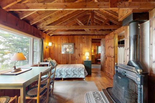 a living room with a fireplace and a bedroom at Bay-View Getaway w/ Deck Between Camden & Belfast! in Northport