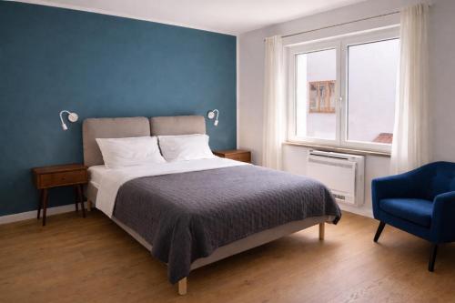 a bedroom with a bed and a blue wall at Casa di Mirea in Grado