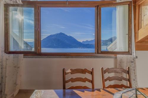 two chairs sitting in front of a window with a view at Il Nido sul Lago in Perledo