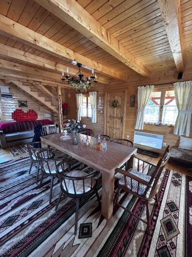 a dining room with a large wooden table and chairs at Casa Dani in Vatra Dornei