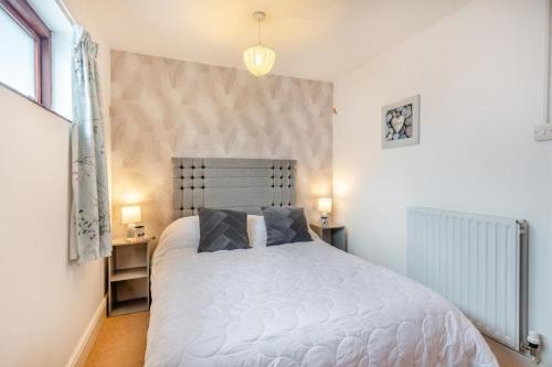 a bedroom with a white bed with two pillows at 2 Bed in Barnby oc-t28265 in North Cove