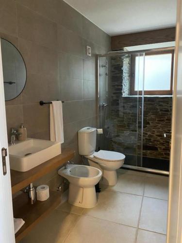 a bathroom with a toilet and a sink and a shower at Casa da Meia Encosta in Arganil