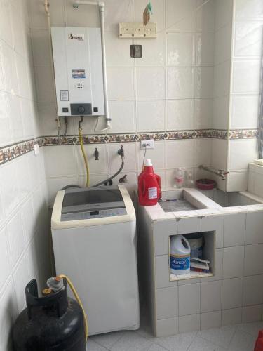 a small kitchen with a sink and a washing machine at Siéntete en casa 2 in Pasto