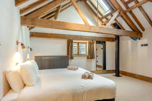 a bedroom with a large white bed with two slippers at 5 Bed in Kings Lynn oc-96250 in Clenchwarton