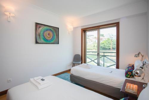 a hotel room with two beds and a window at Liiiving in Porto - Douro Riverside Apartment in Porto