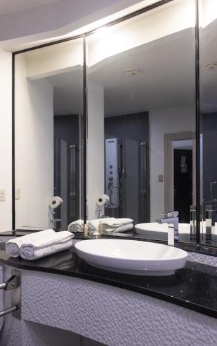 a bathroom with a large sink and a large mirror at Ceibo Real in Portoviejo