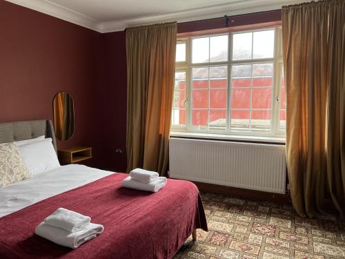 a bedroom with a bed with two towels on it at Zozy Anson in London