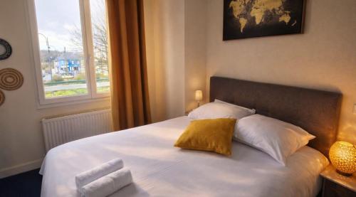 a bedroom with a bed with two pillows and a window at Aux Genêts D'Or in Trévé