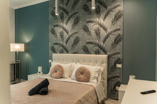 a bedroom with a large bed with a large leaf wallpaper at Palazzo Margò - Private Luxury Palace with Sea View in Mola di Bari