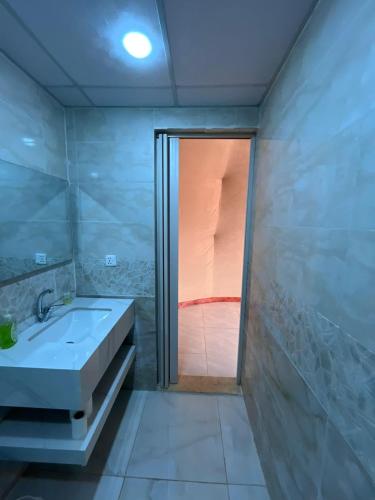 a bathroom with a shower and a sink and a glass door at Wadi rum camp teem in Wadi Rum