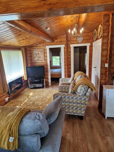 a living room with a couch and a tv at Cabin Retreat in Trawsfynydd