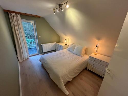 a bedroom with a white bed and a window at Silk and Stone Manor in Grez-Doiceau