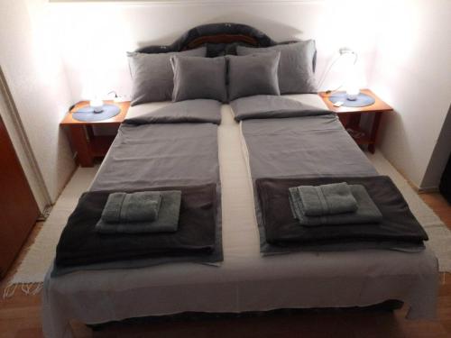 a large bed with two nightstands and two tables at Apartman Djokic 1 in Požarevac