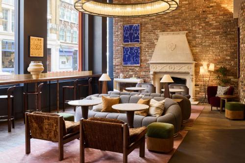 a lobby with couches and tables and a fireplace at The Hoxton, Shoreditch in London