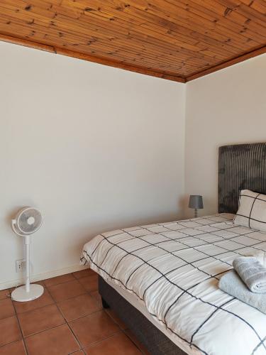 a bedroom with a bed and a wooden ceiling at Kubata Diame B&B in Cape Town